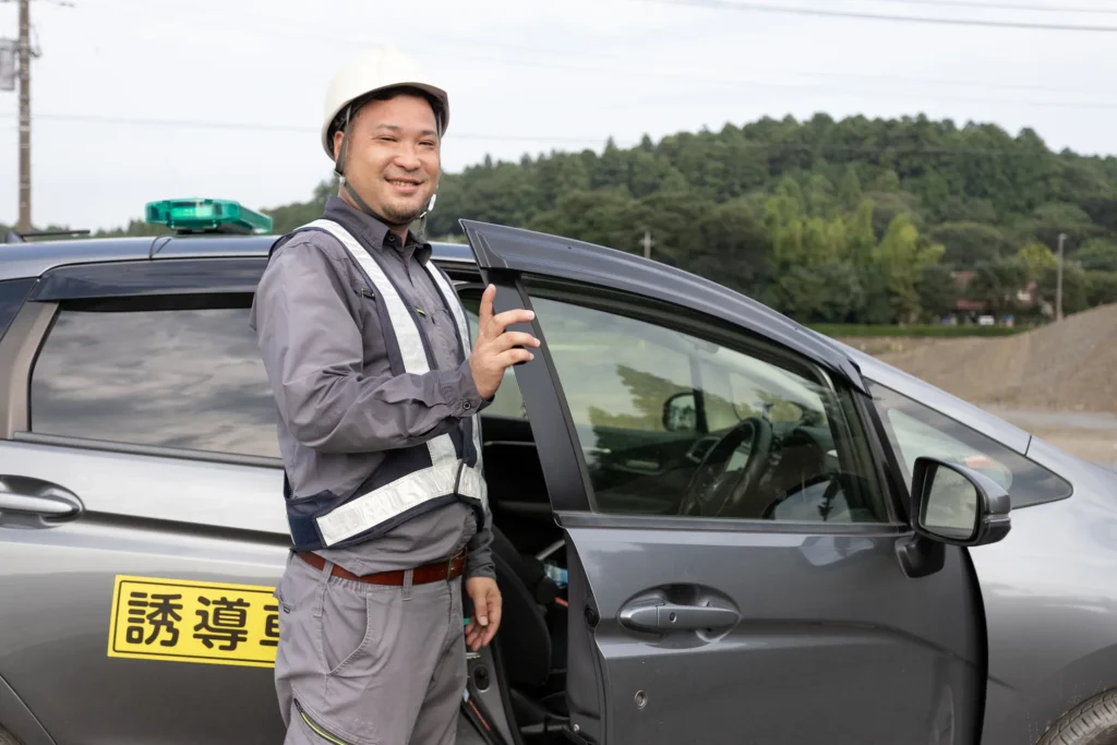 誘導車両の運転席に乗り込む誘導員